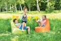 Kinder sitzen im Freien auf einem Sitzsack
