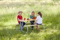 Kinder im Grünen sitzen auf der Garnitur