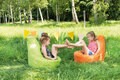 Kinder sitzen im Freien auf einem Sitzsack
