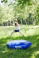 Hüppeding auf Wiese mit springenden Kind
