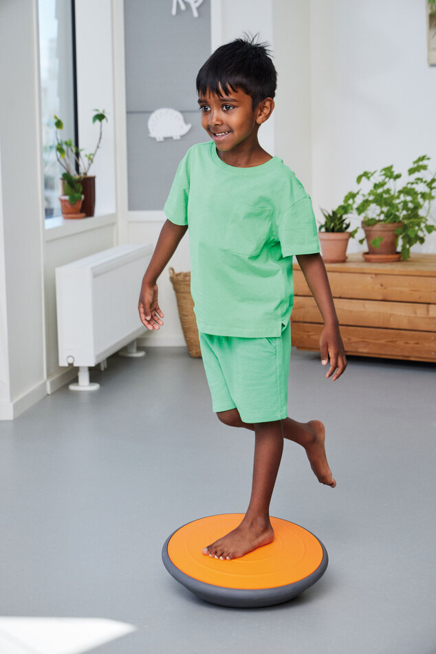 Air Board klein orange mit Kind stehend im Raum
