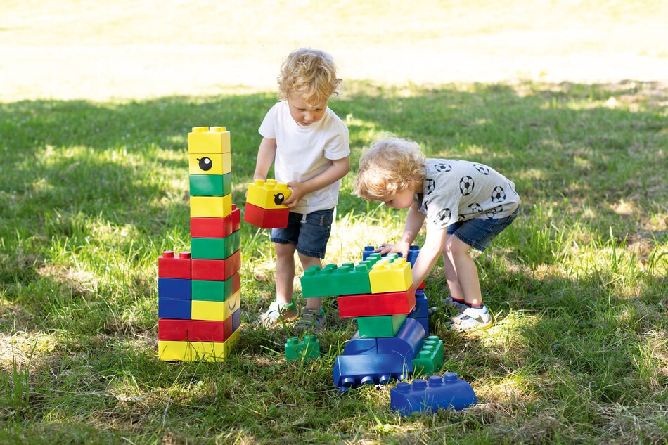 Kinder spielen mit den Bausteinen draußen