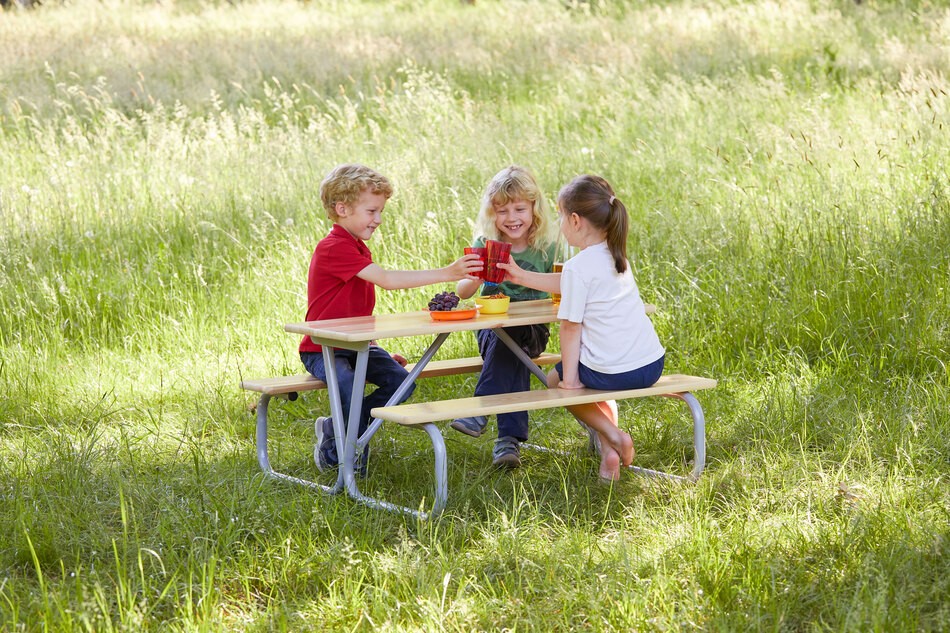 Kinder im Grünen sitzen auf der Garnitur