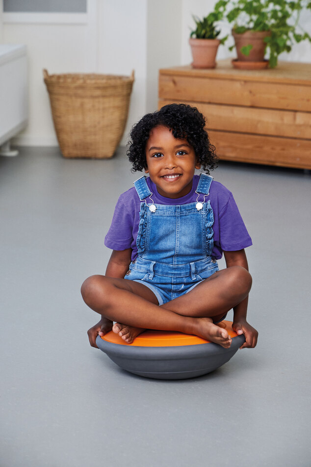 Air Board klein orange mit Kind sitzend im Raum