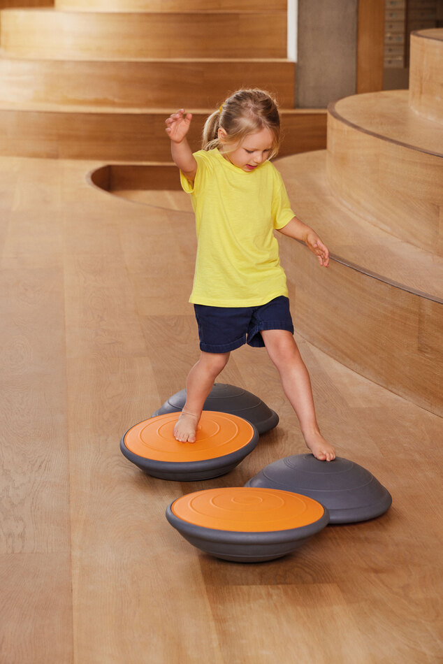 Air Board klein orange mit Kind stehend im Raum