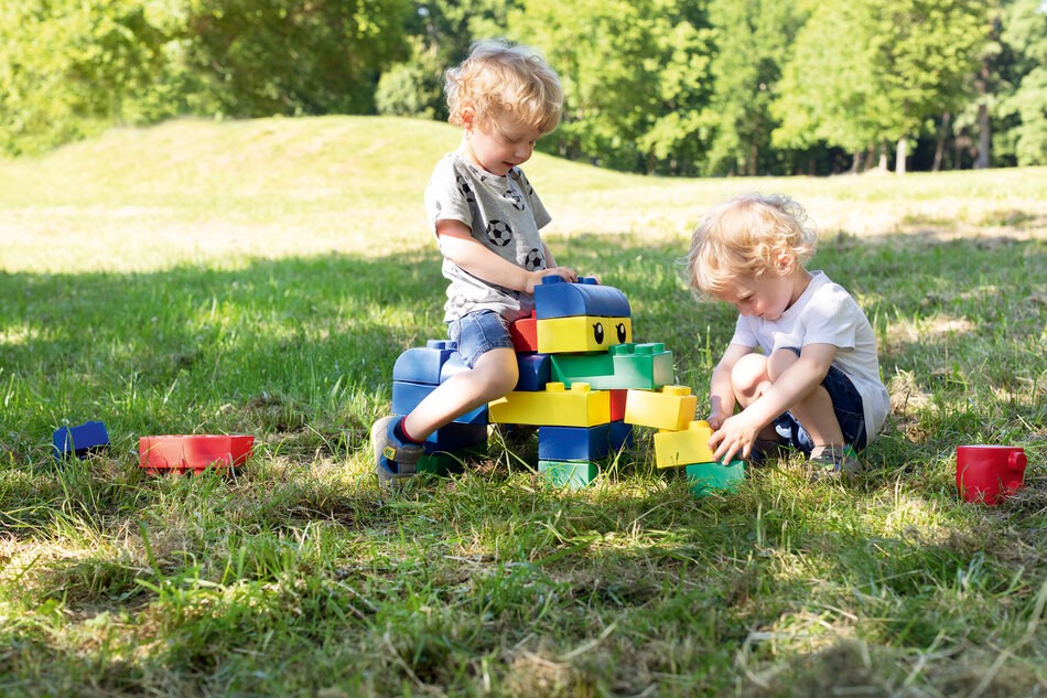 Kinder spielen mit den Bausteinen draußen