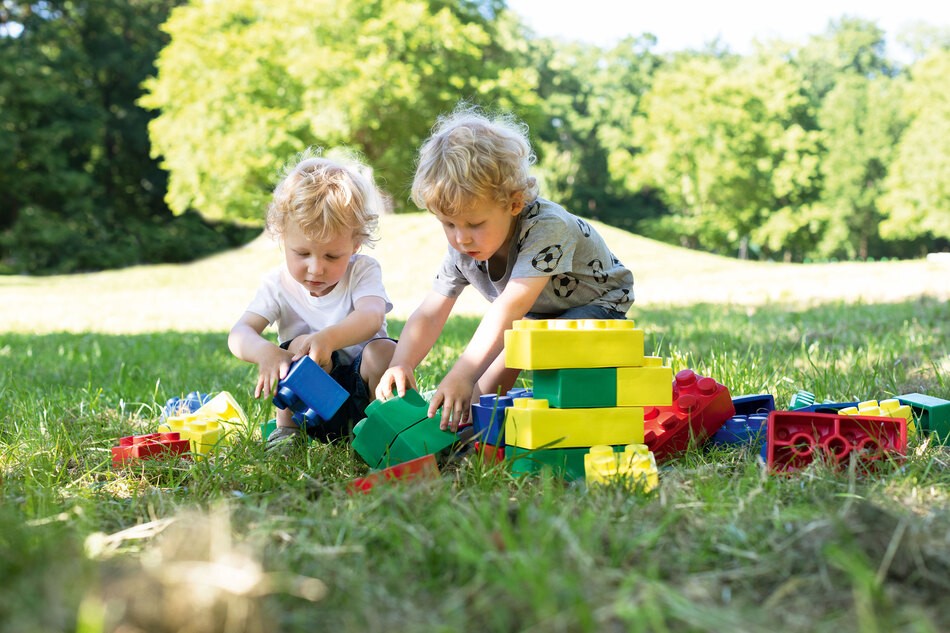 Kinder spielen mit den Bausteinen draußen