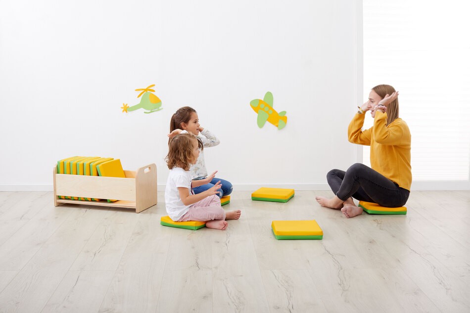 Kinder sitzen auf dem Sitzkissen